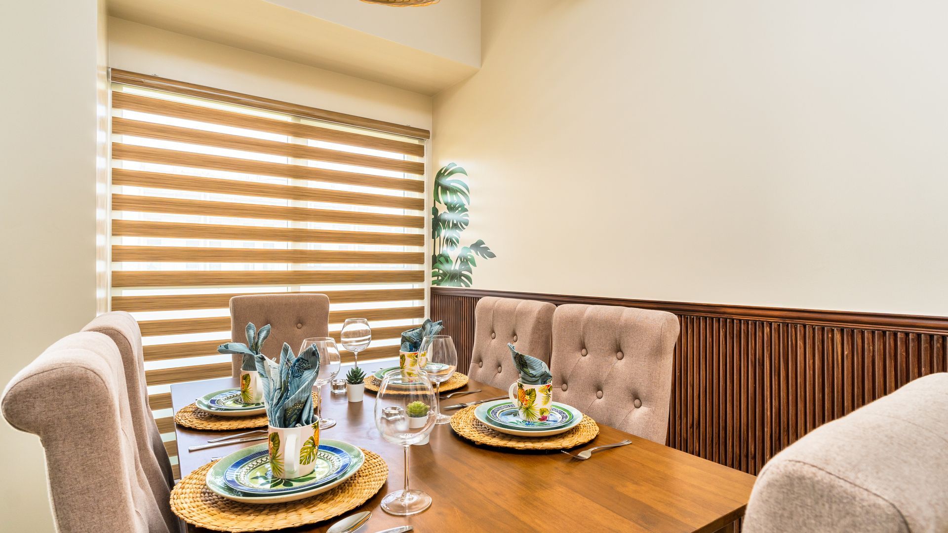 Dining table with faux suede beige chairs and tropical plates  and cups