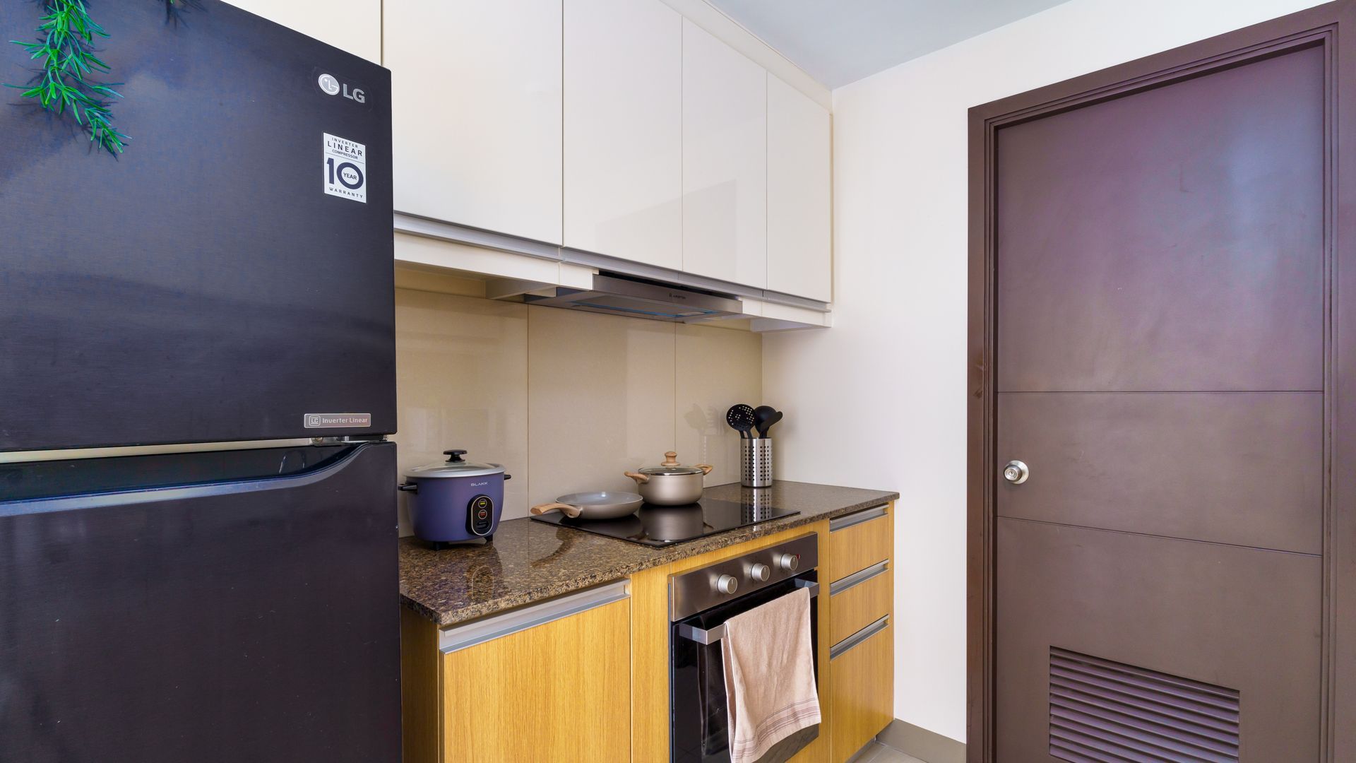 Tall Fridge Freezer next to a kitchen counter with hobs and oven