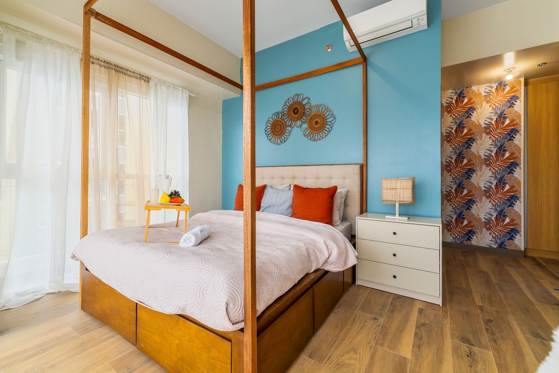 A bedroom with a canopy bed , nightstand , and dresser.