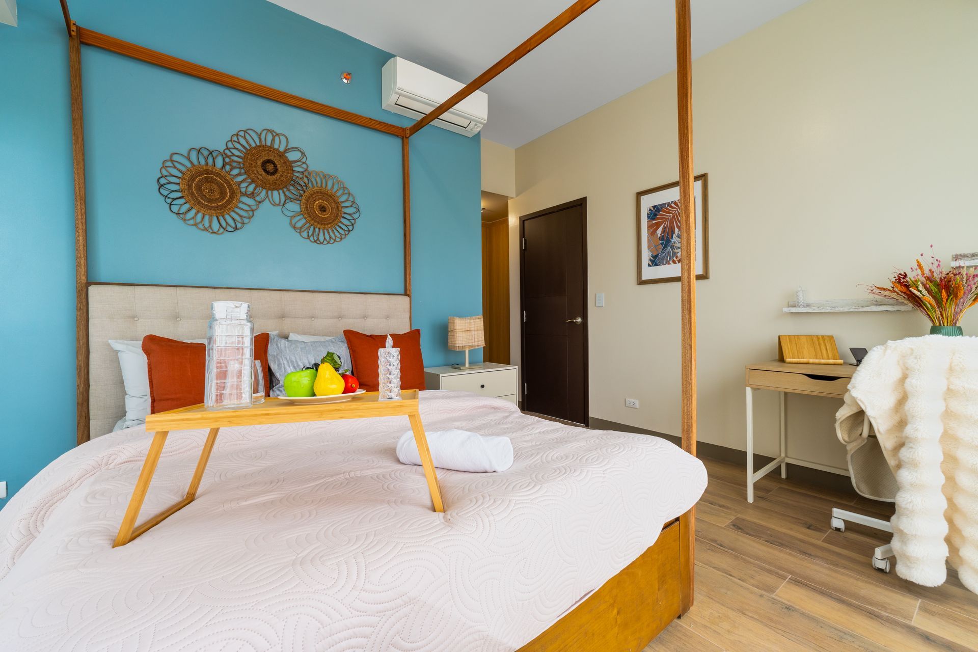 A bedroom with a canopy bed and a tray on the bed.