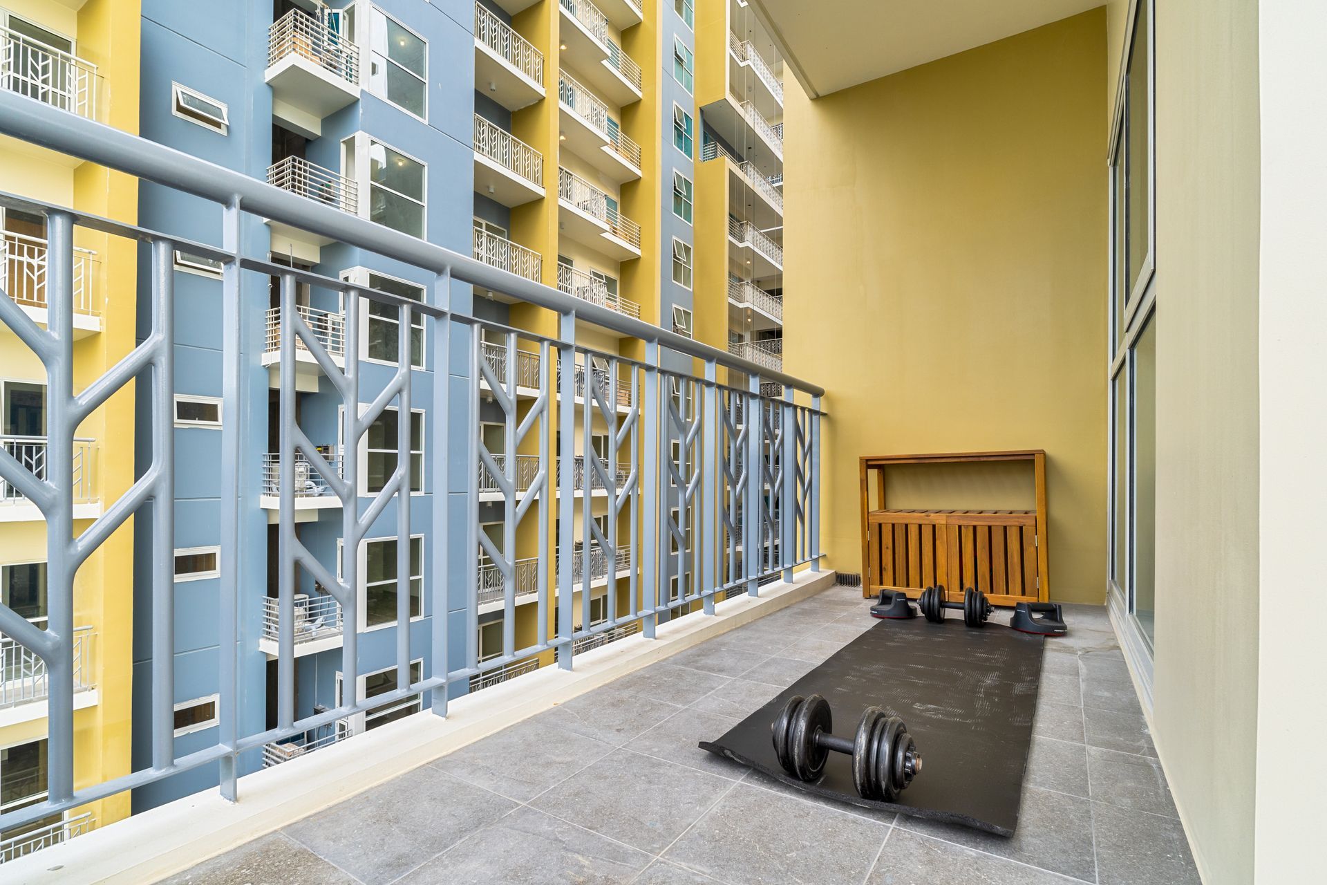 A balcony with a dumbbell and a mat on it.