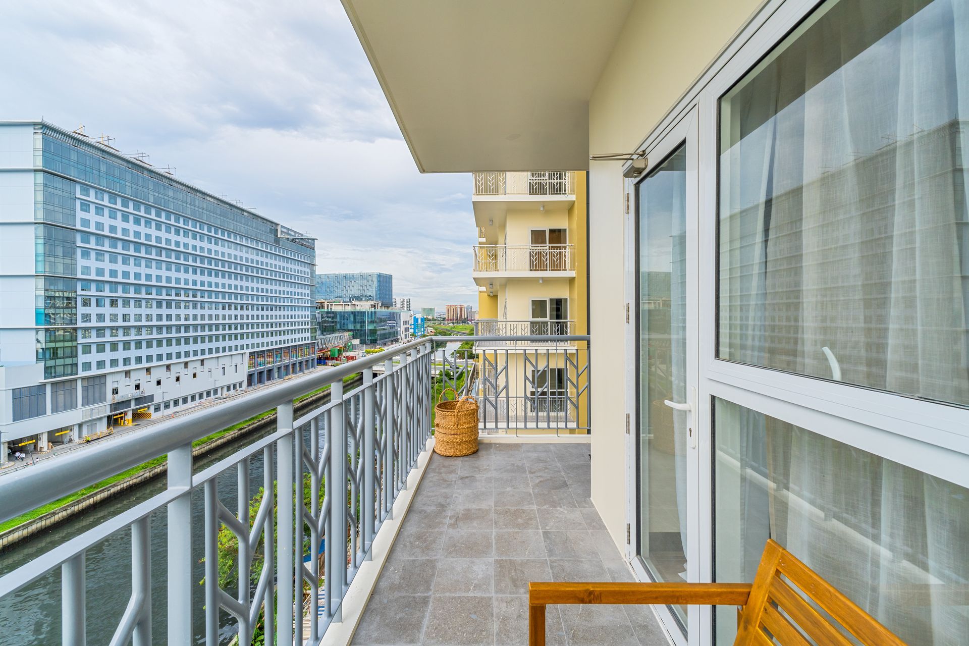 A balcony with a chair and a view of a city.