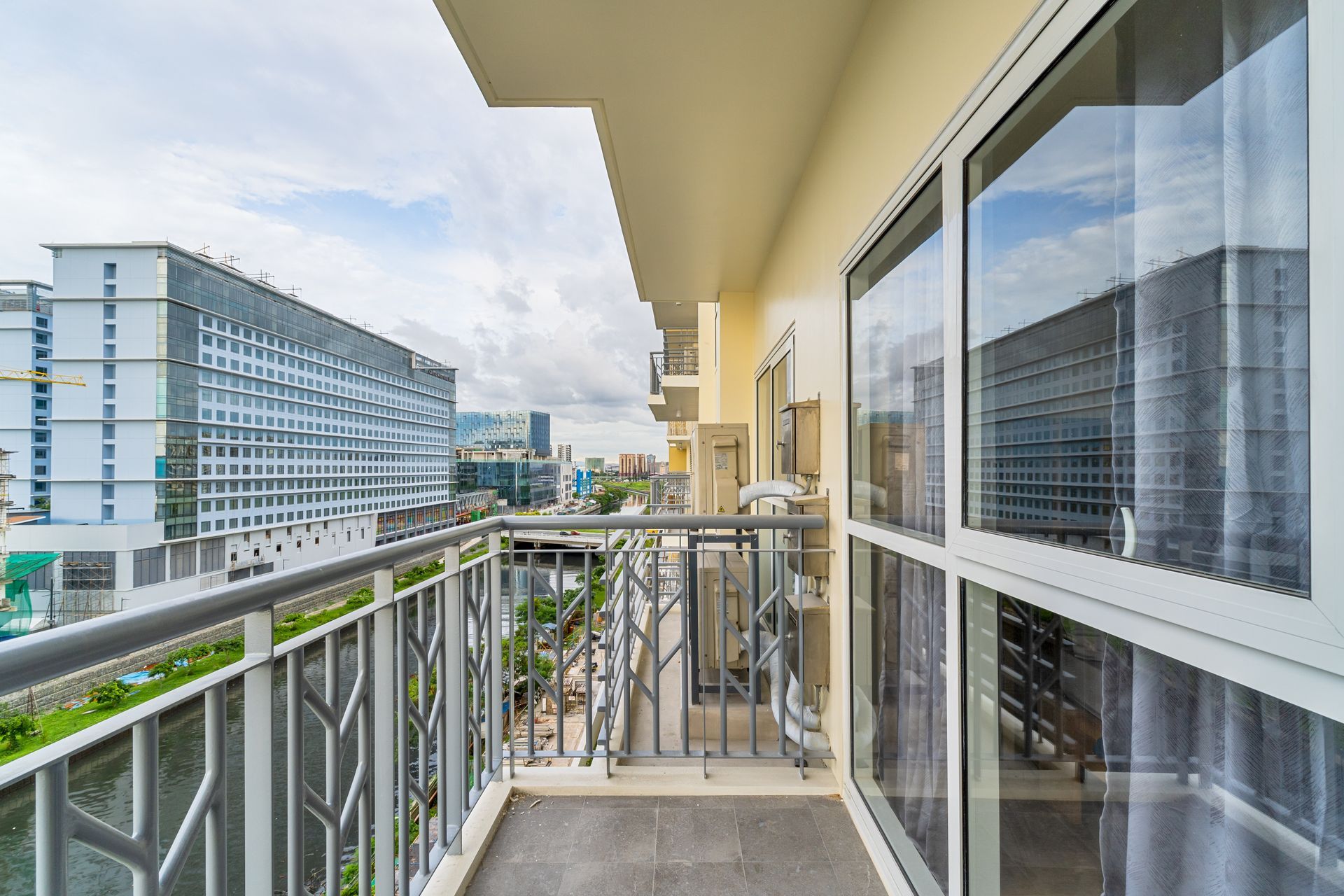 A balcony with a railing and a view of a city.