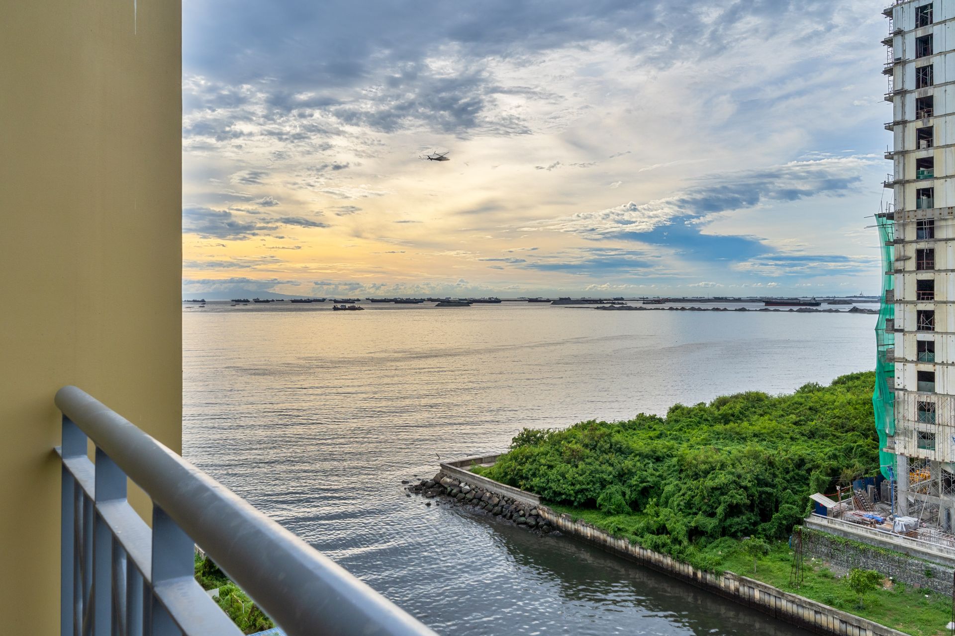 A balcony overlooking a body of water with a building in the background