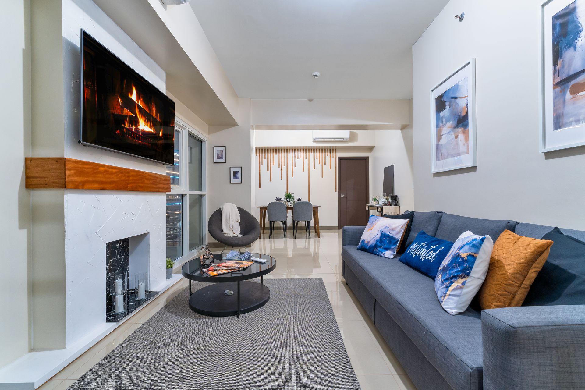 A living room with a couch , fireplace and television. Captains Quarters at Bayshore Luxe by Prime, Manila