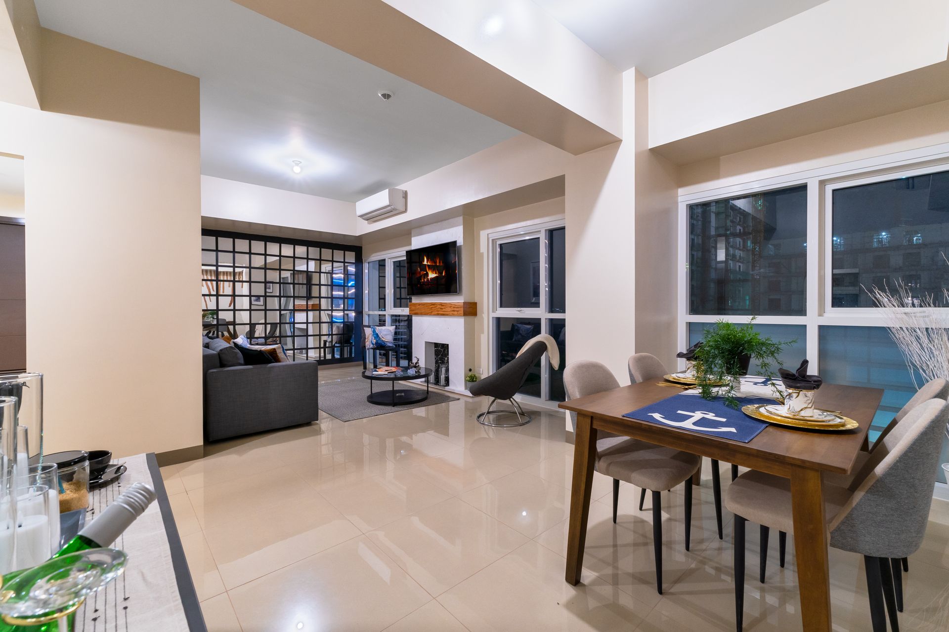 A living room with a dining table and chairs and a fireplace.  Captains Quarters at Bayshore Luxe by Prime, Manila