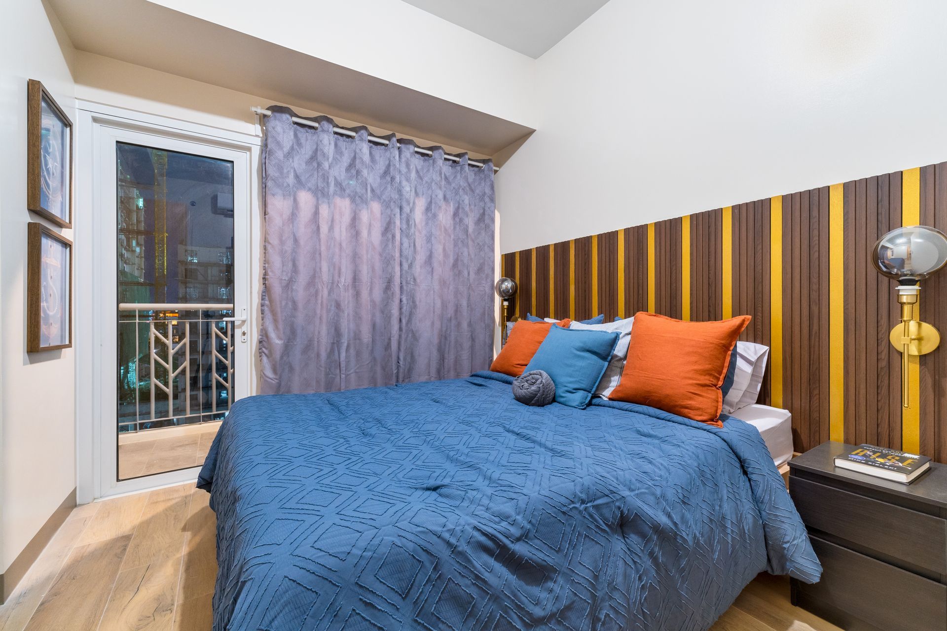 Bedroom with bed, nightstand, & door to a balcony. Captains Quarters at Bayshore Luxe by Prime, Manila
