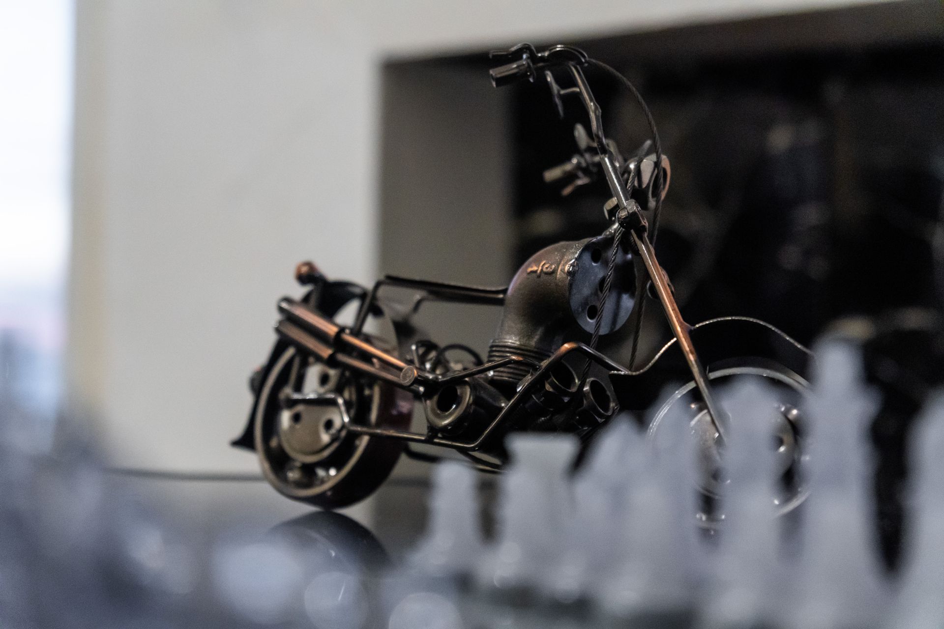 A toy motorcycle is sitting on a table next to a crystal chess board. Captains Quarters at Bayshore Luxe by Prime, Manila