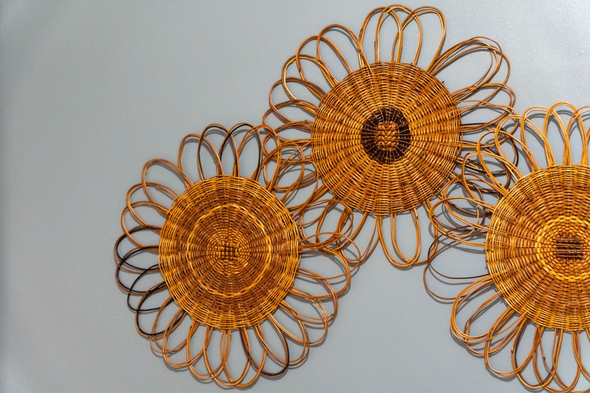 A close up of three gold flowers on a white background
