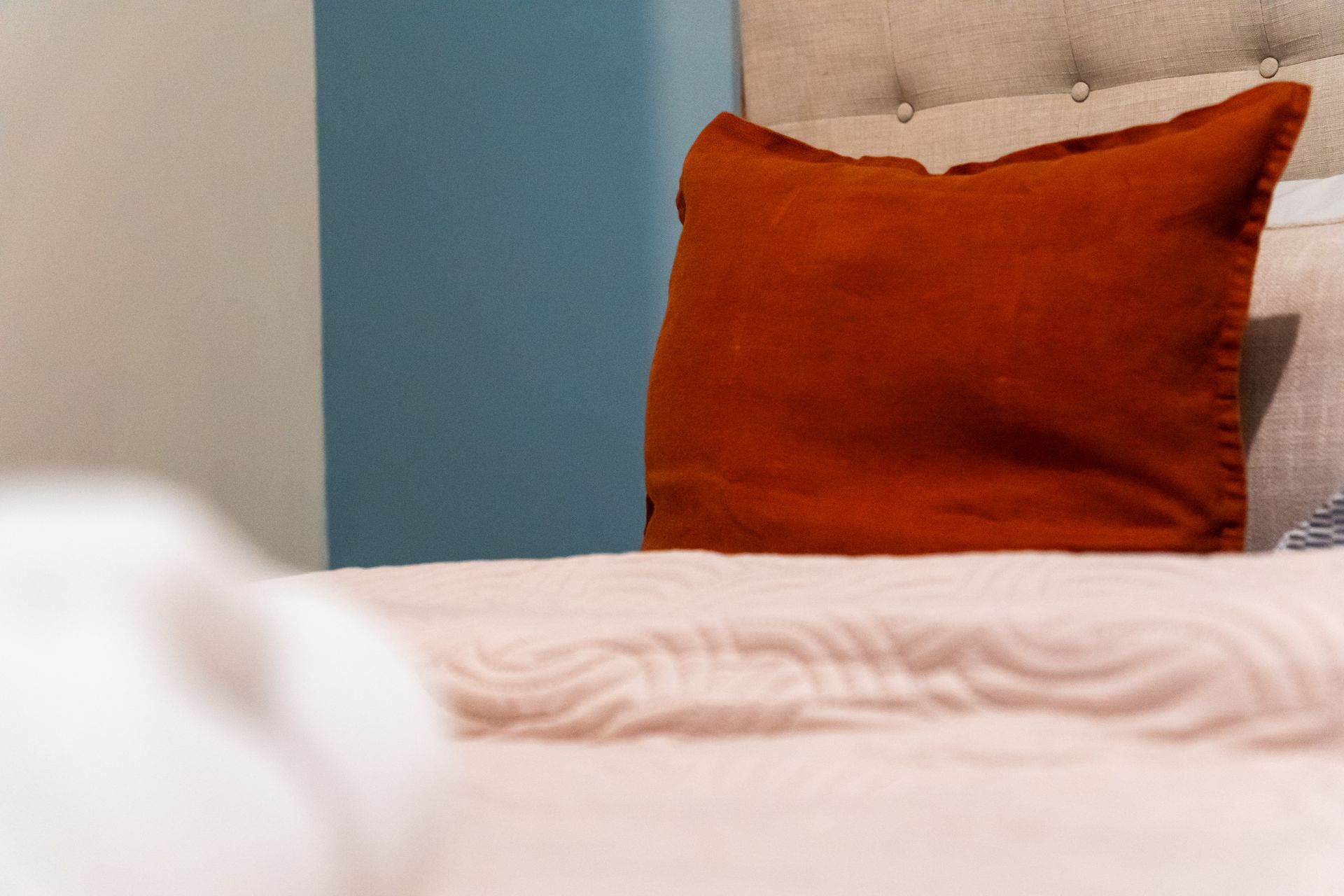 A bed with a red pillow on it in a bedroom.