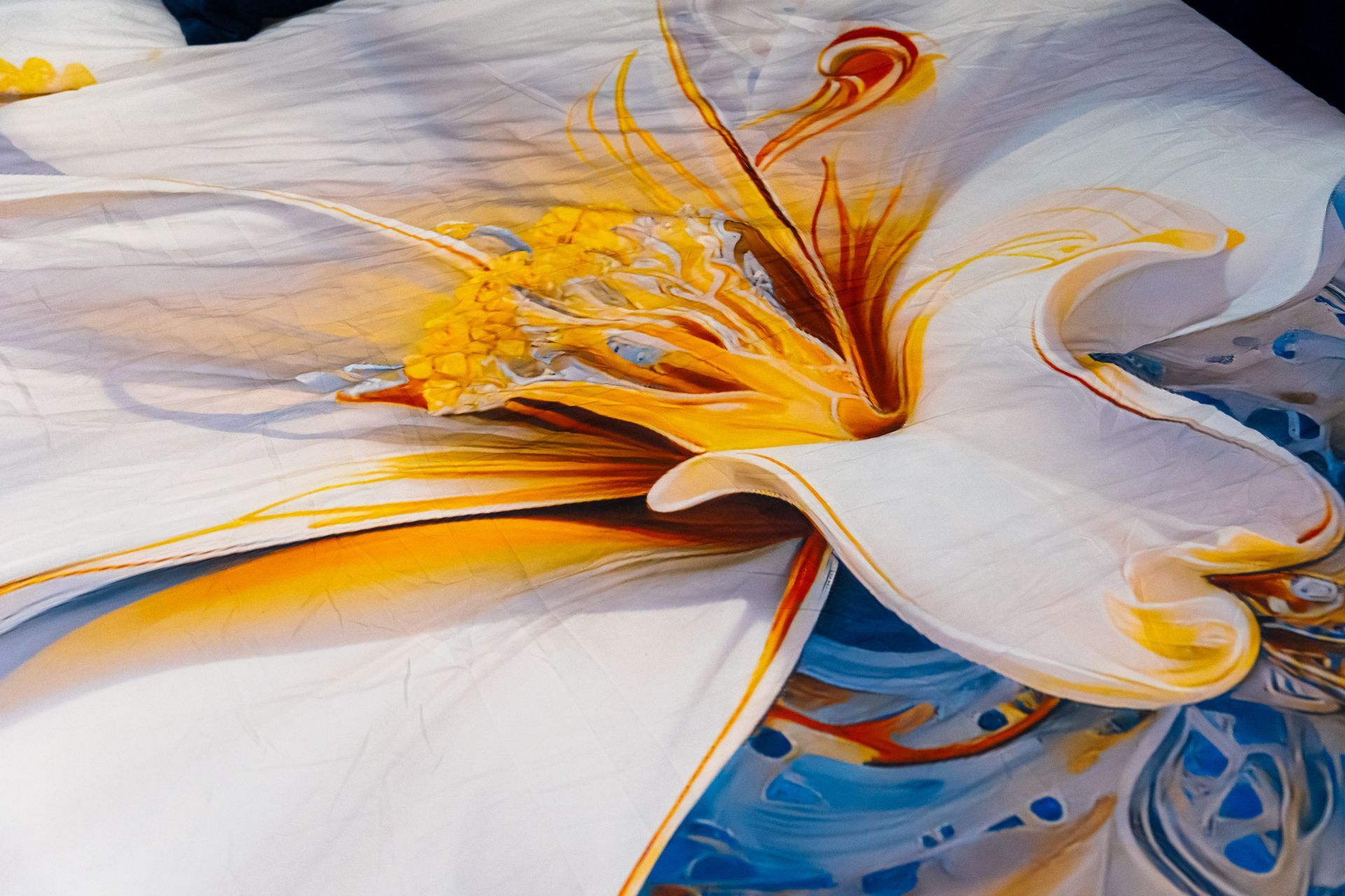 A close up of a painting of a flower on a bed