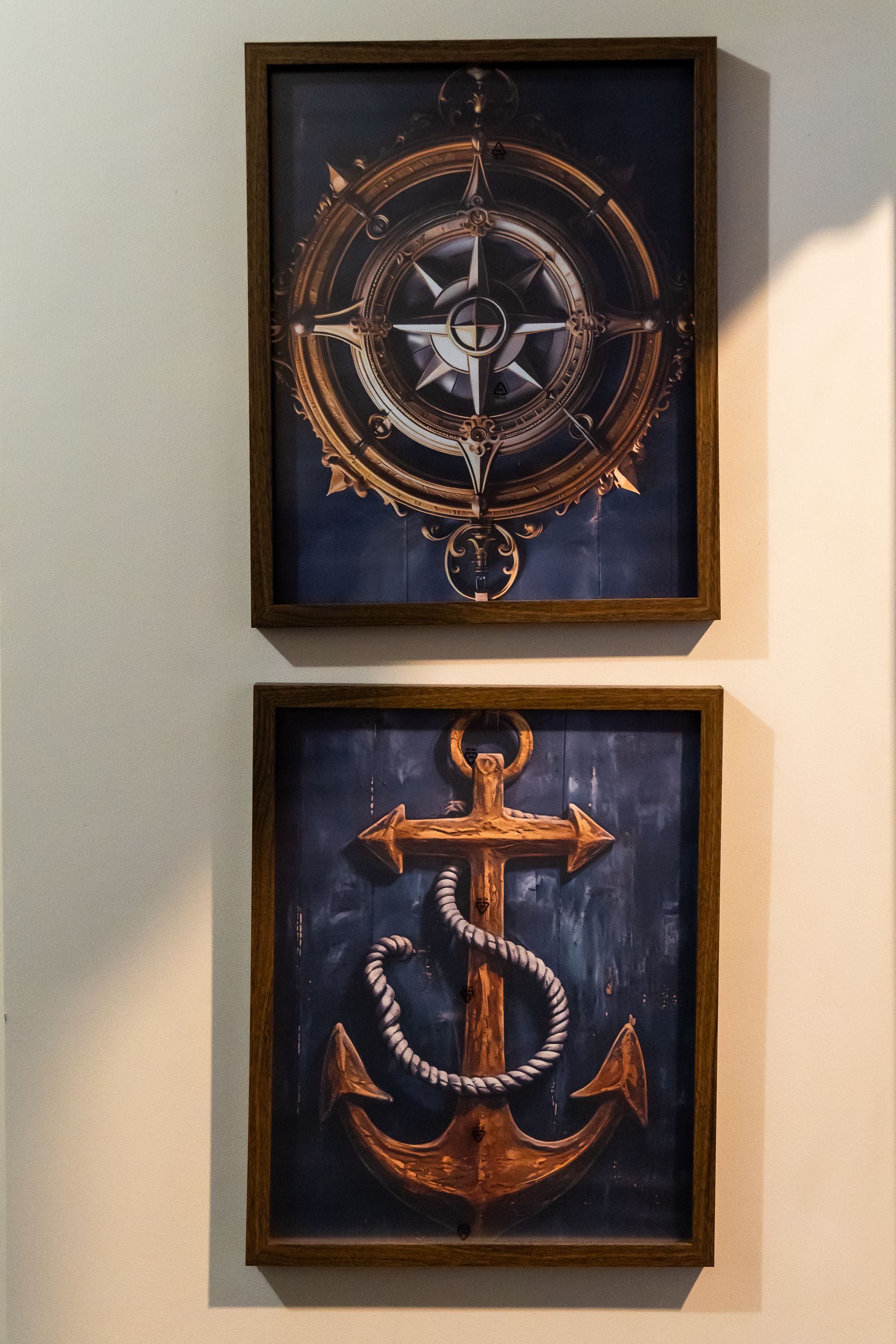 Two framed pictures of an anchor and a compass on a wall Captains Quarters at Bayshore Luxe by Prime, Manila