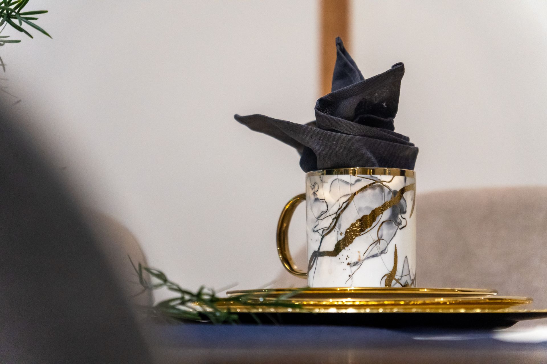 A cup with a napkin in it is sitting on a table.