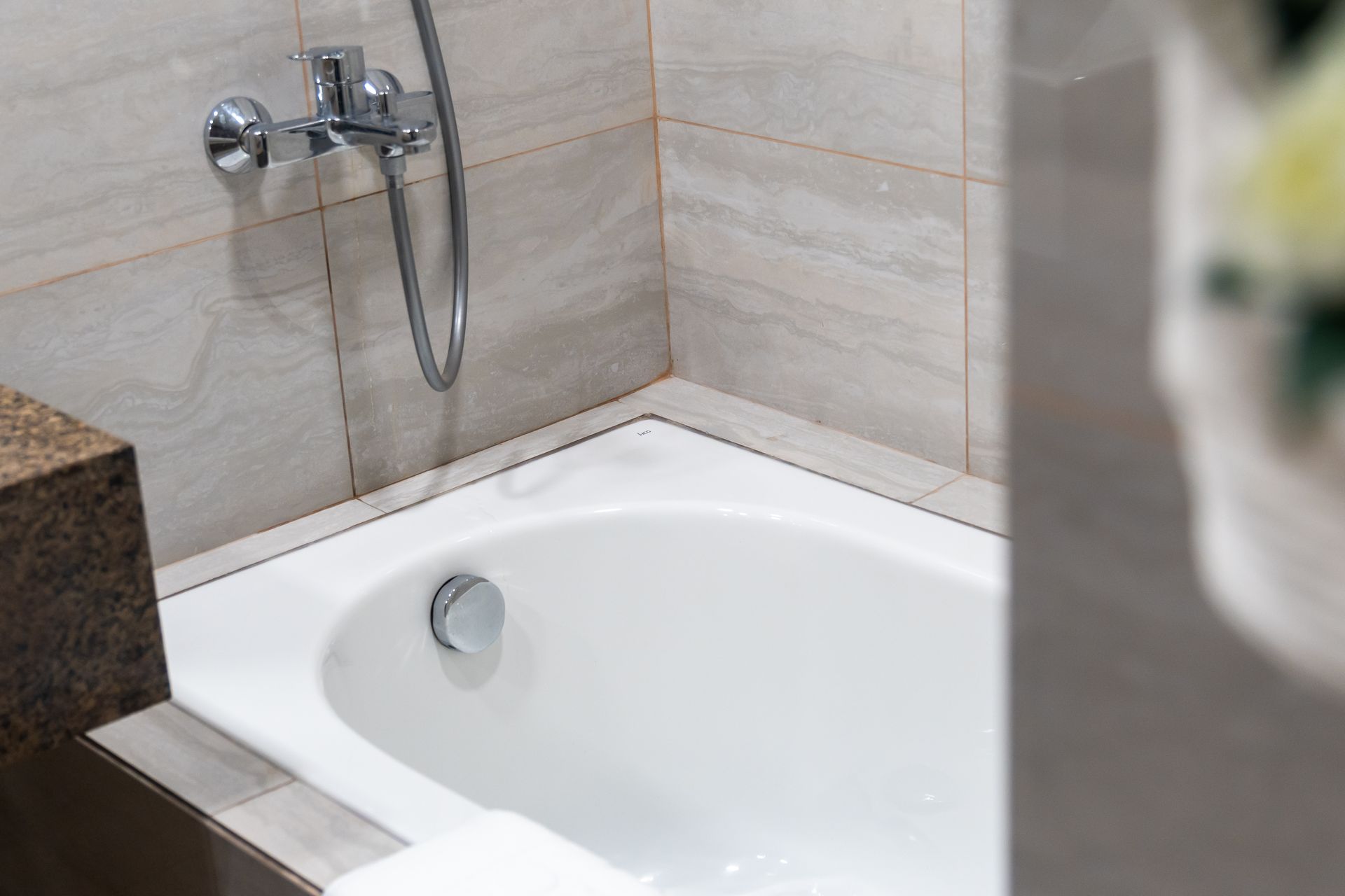 Photo of a white bathtub with shower 