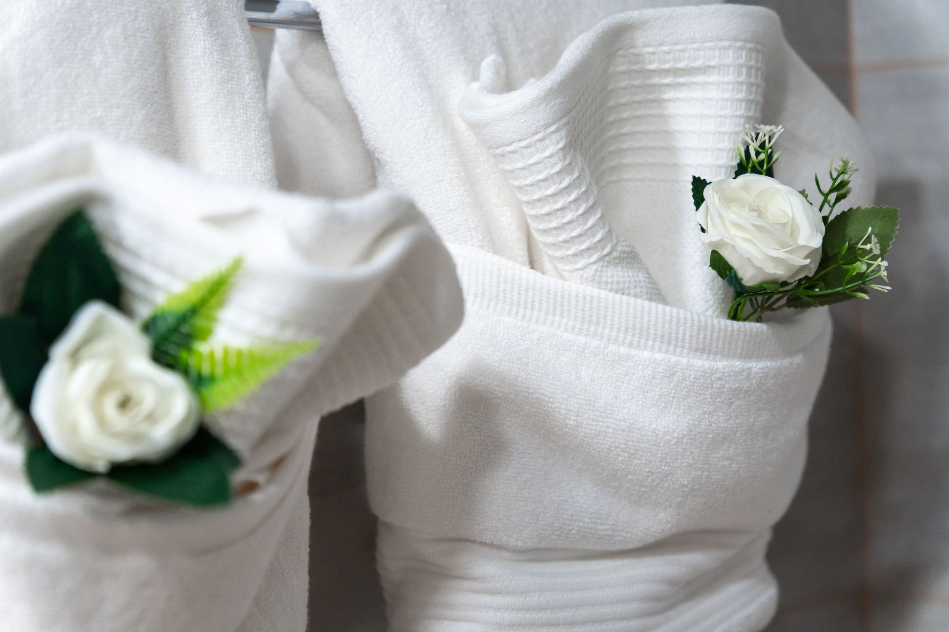 A close up of a white towel with a flower in it.
