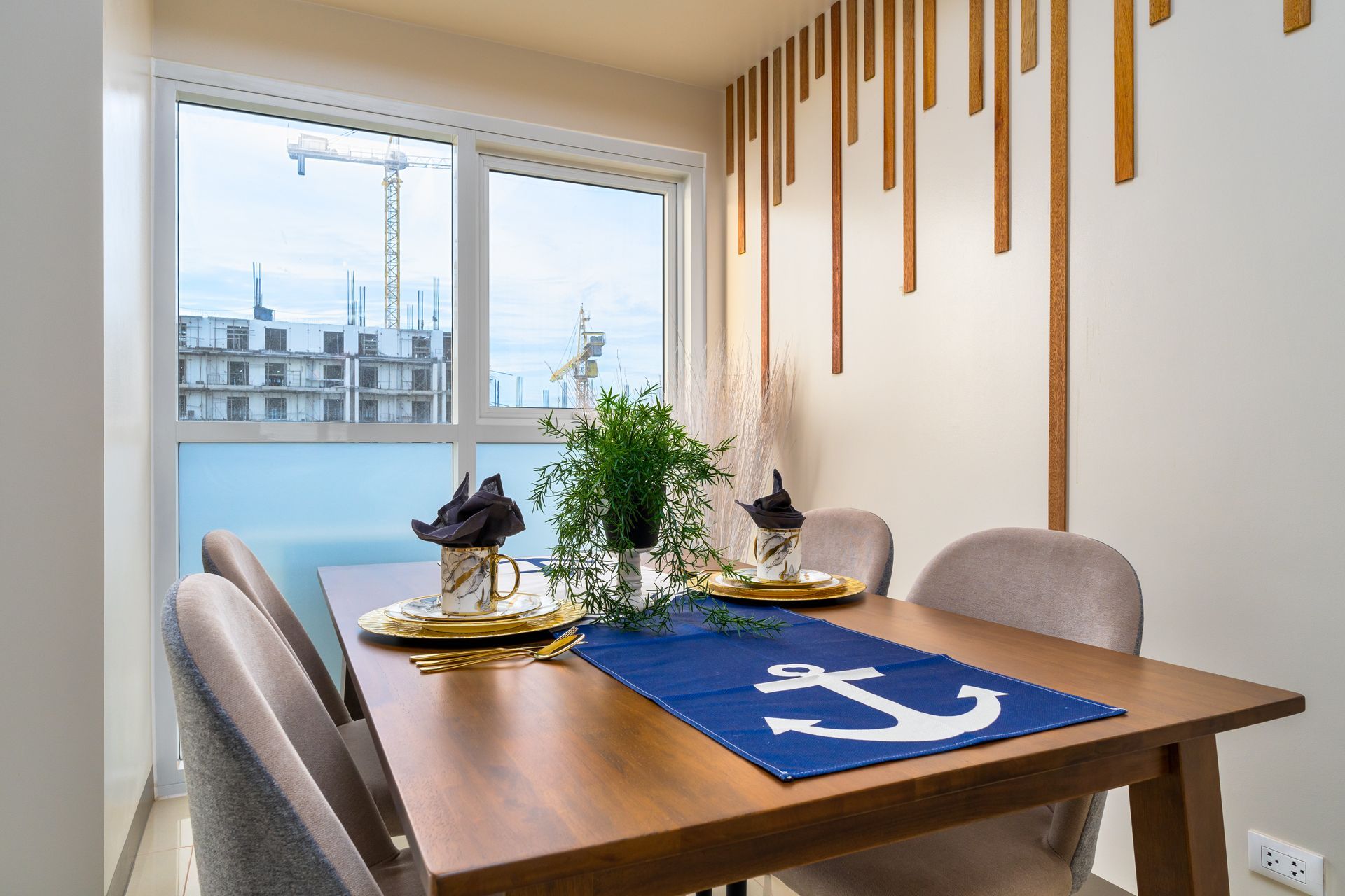 Dining table with a blue table runner, with white Anchor, feature wall behind