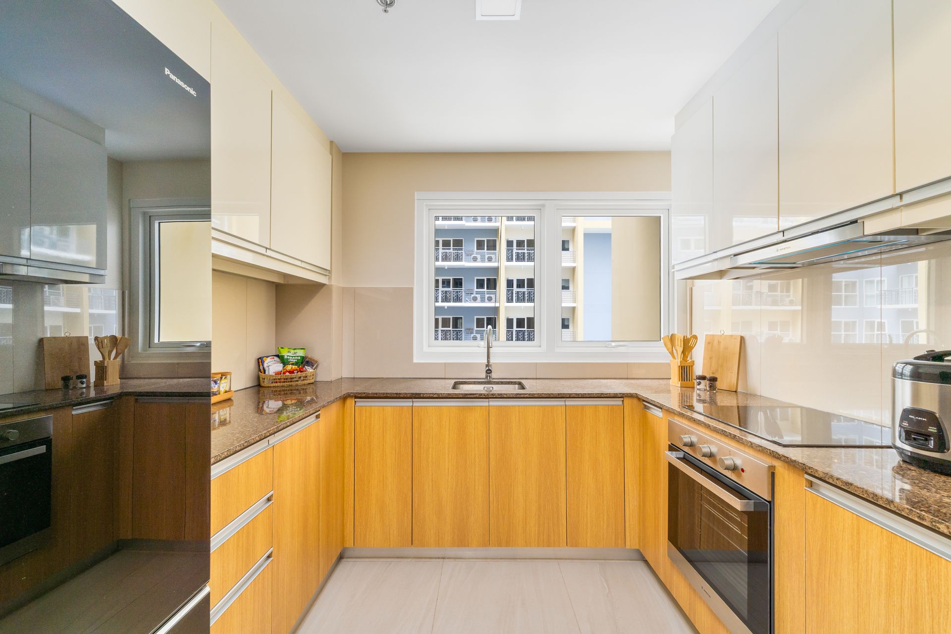 horseshoe style kitchen with sink, counter tops, a window and fridge 