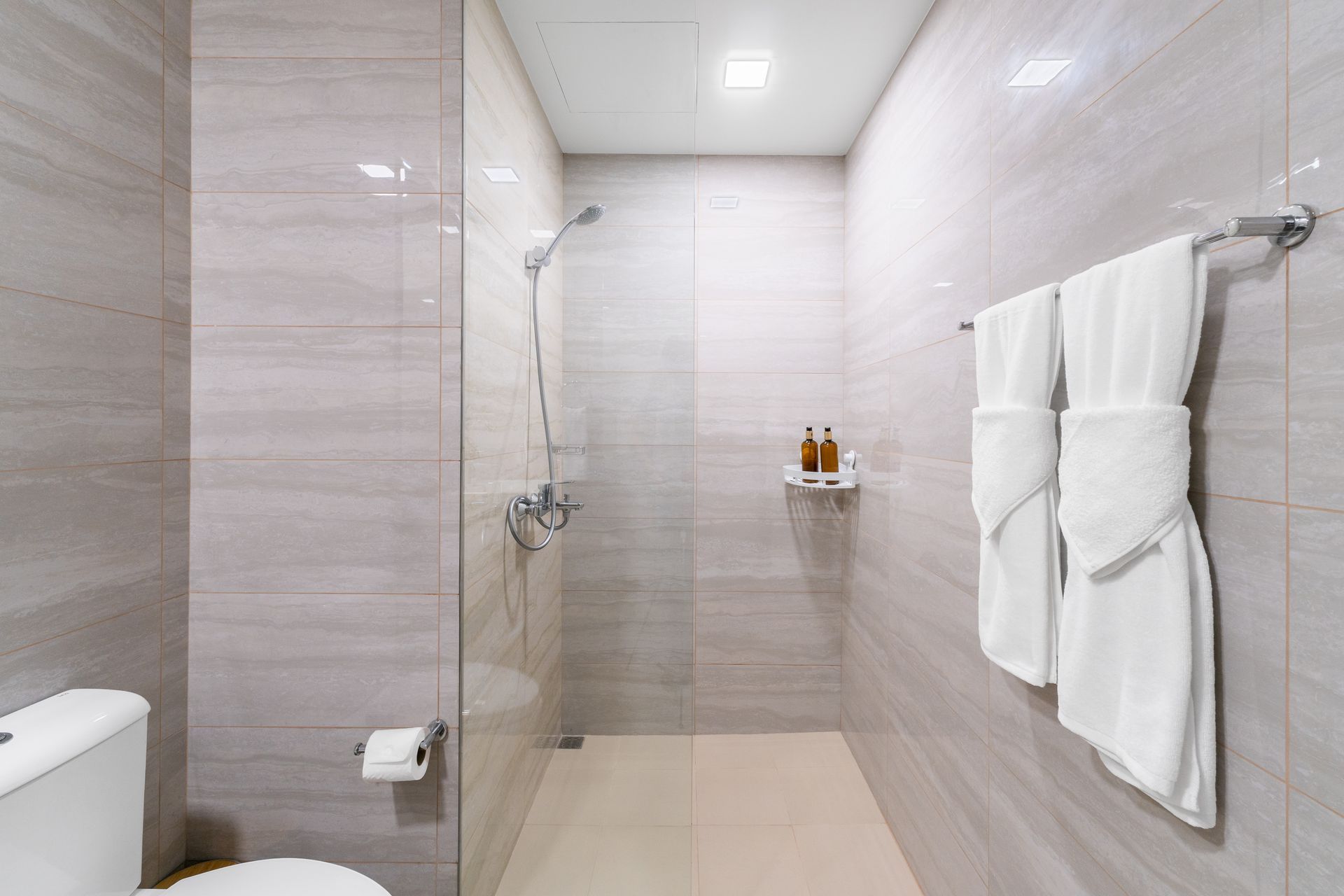 A tiled marble effect bathroom with walk in shower 