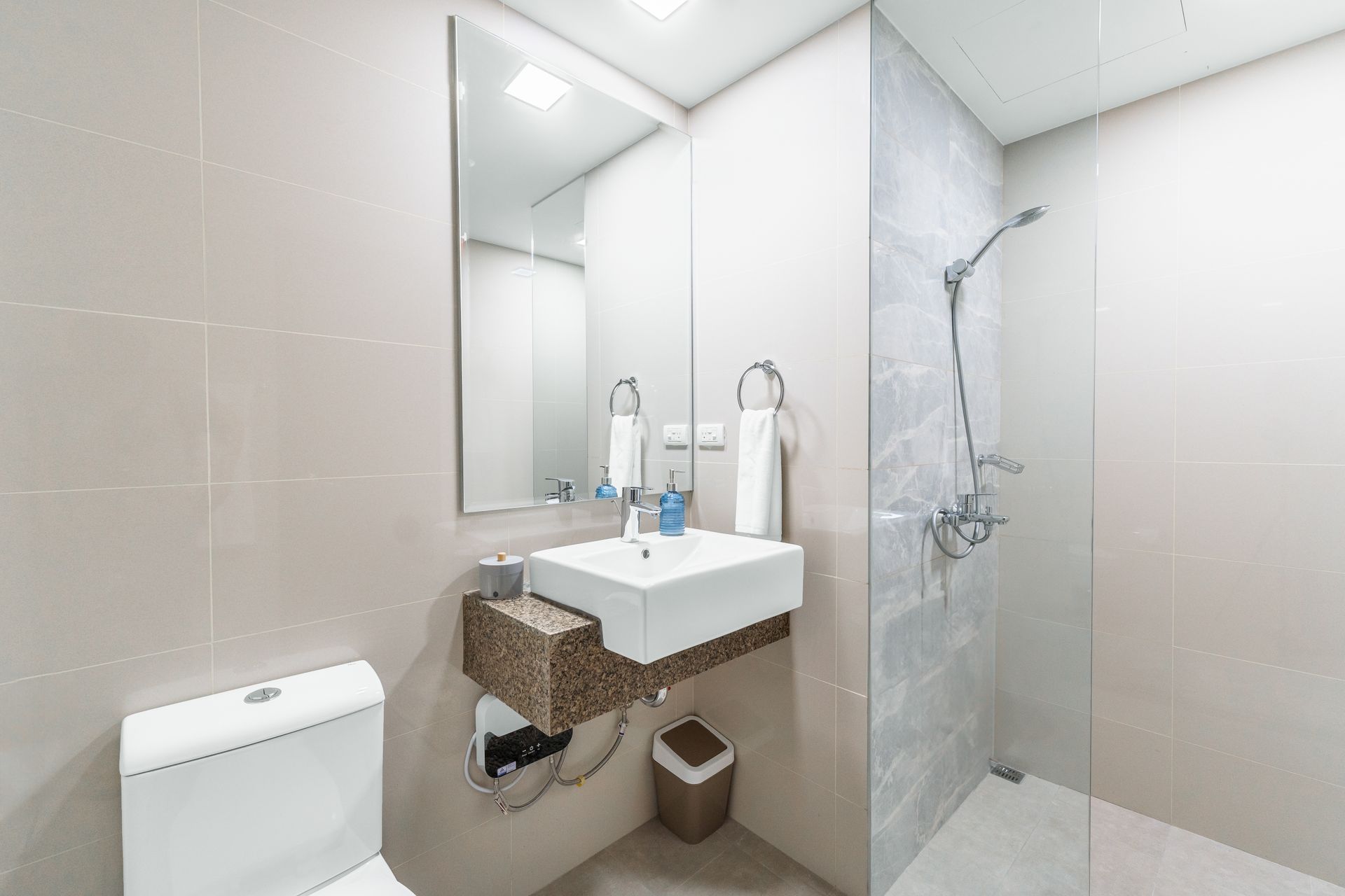 A tiled marble effect bathroom with walk in shower 