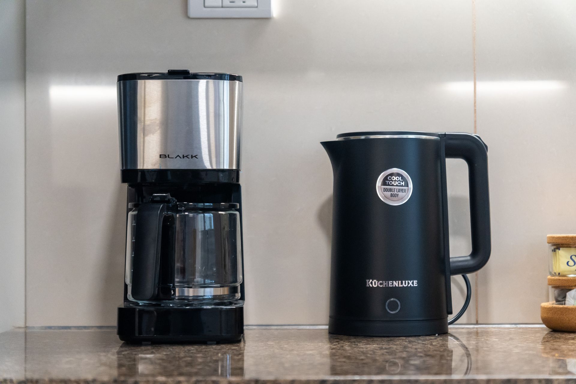 A black and chrome coffee maker and kettle