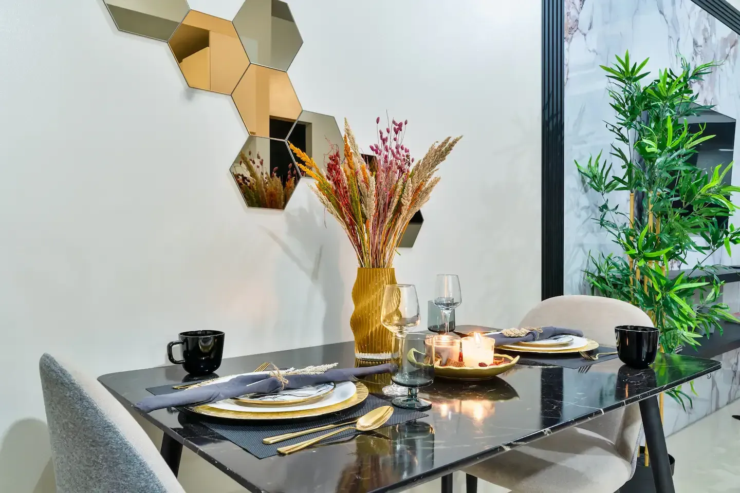 A dining room table with plates , utensils , and a vase of flowers on it.    The Den at Bayshore Luxe by Prime, Manila