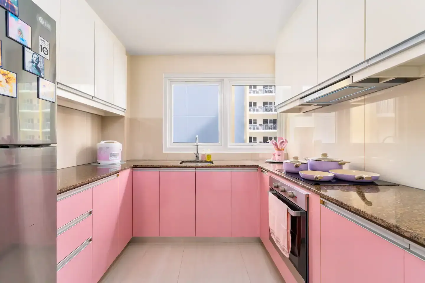 A kitchen with pink cabinets and white counter tops at Bayshore Luxe by Prime, Manila