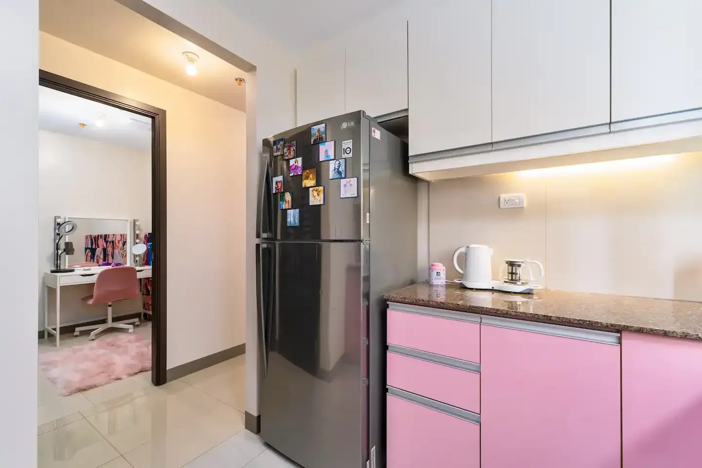 A kitchen with pink cabinets and a stainless steel refrigerator at Bayshore Luxe by Prime, Manila