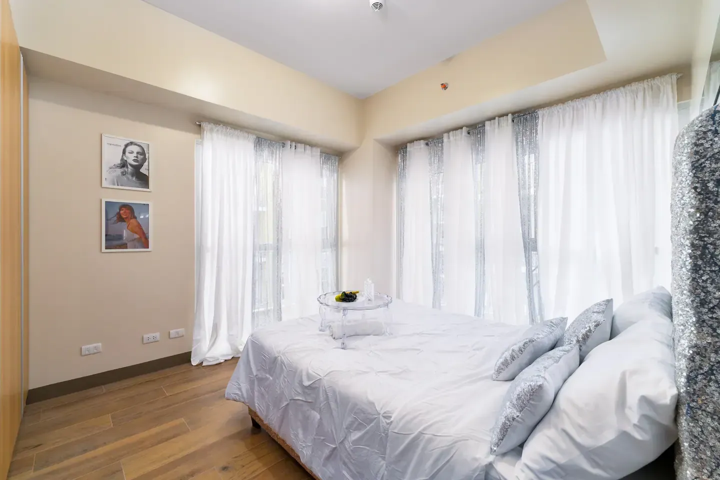 A bedroom with a large bed, silver headboard and lots of windows at Bayshore Luxe by Prime, Manila