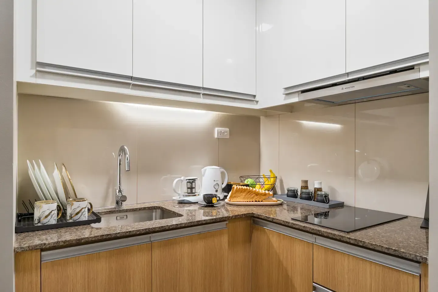 A kitchen with a sink , stove , and dishwasher.  The Den at Bayshore Luxe by Prime, Manila