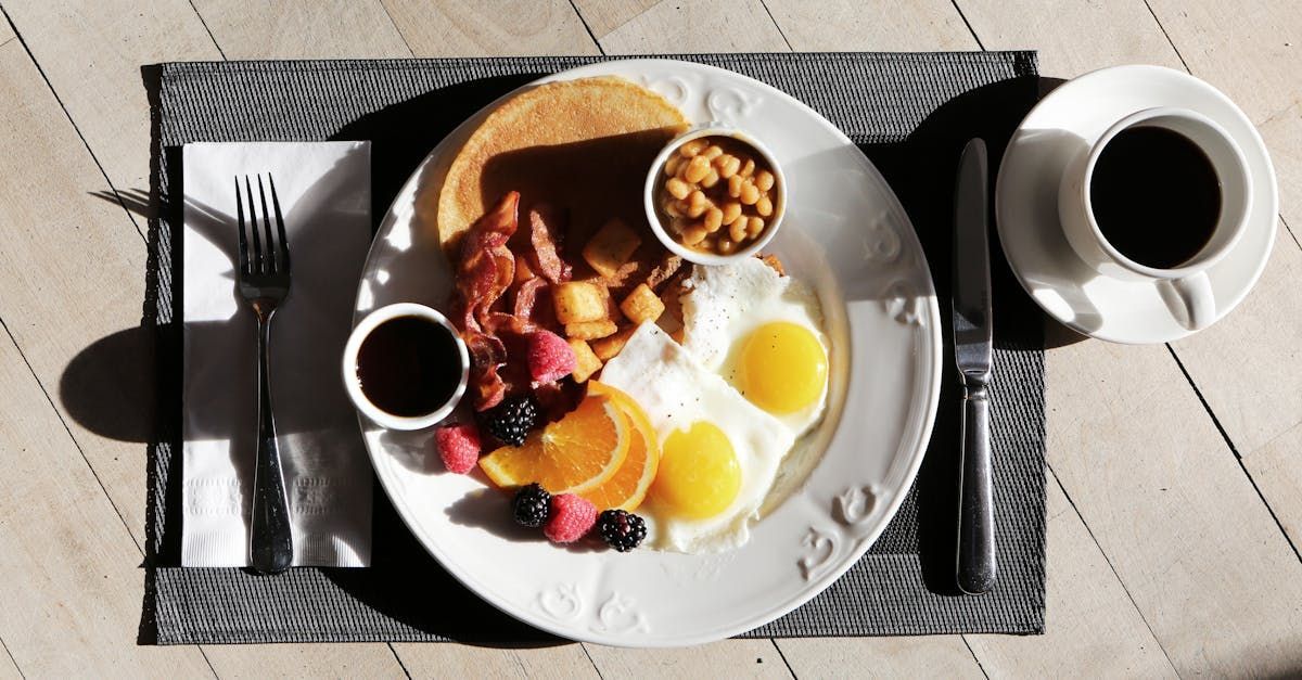 A plate of food on a table with a cup of coffee