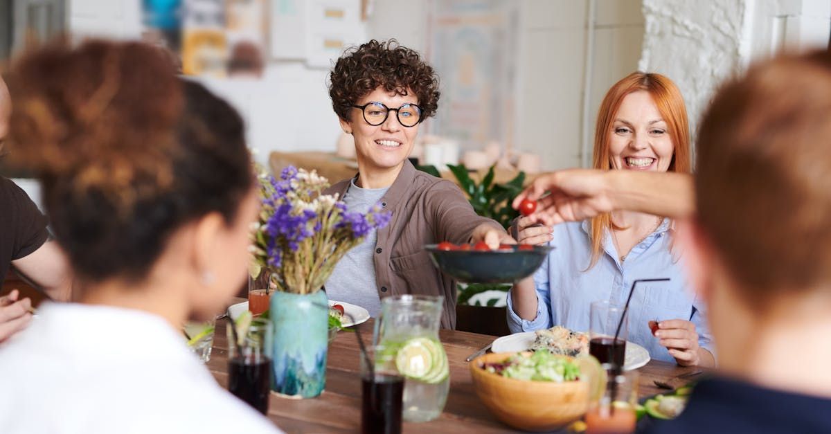 A group of people are sitting around a table eating food.