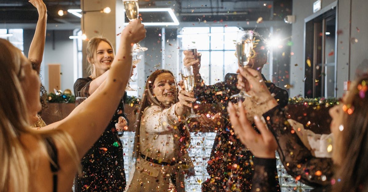 A group of people are toasting with champagne and confetti at a party.