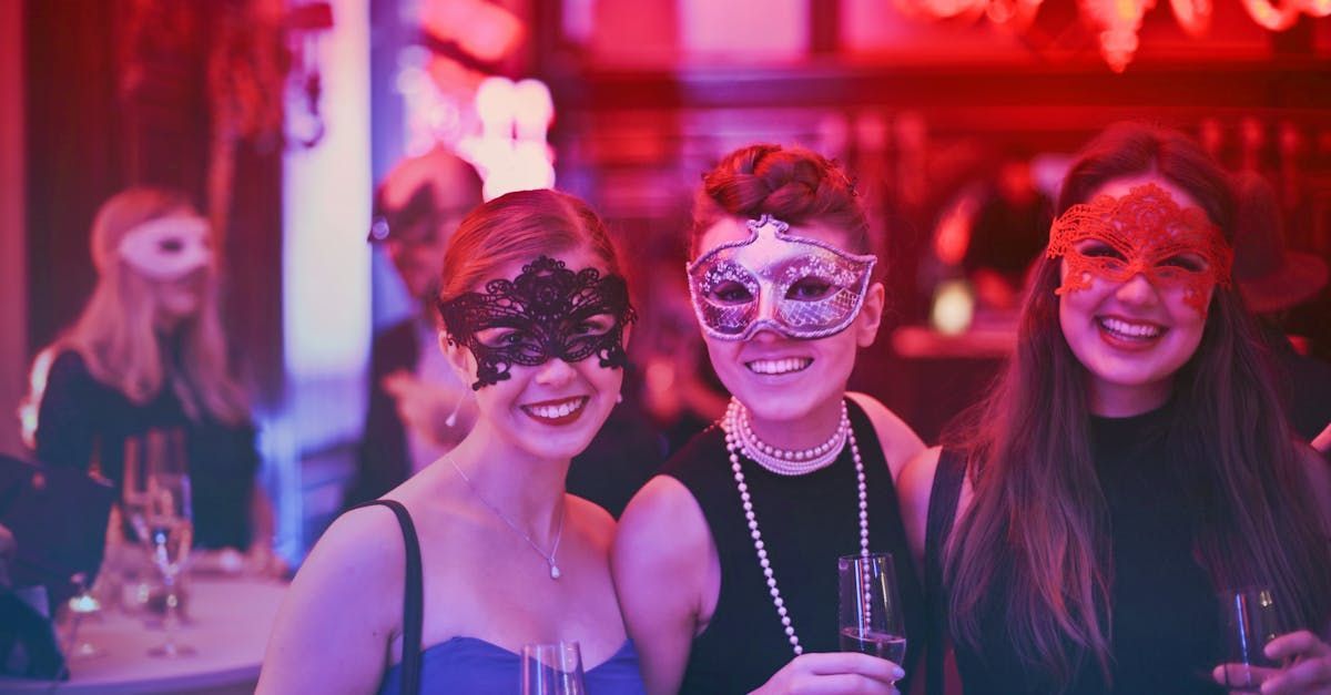 Three women wearing masks are posing for a picture at a party.