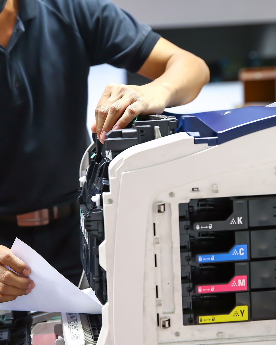 A man is working on a printer