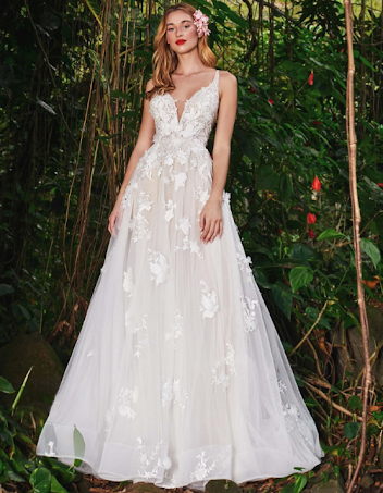 Woman in a white, off-the-shoulder mermaid wedding dress with lace detailing, posing.