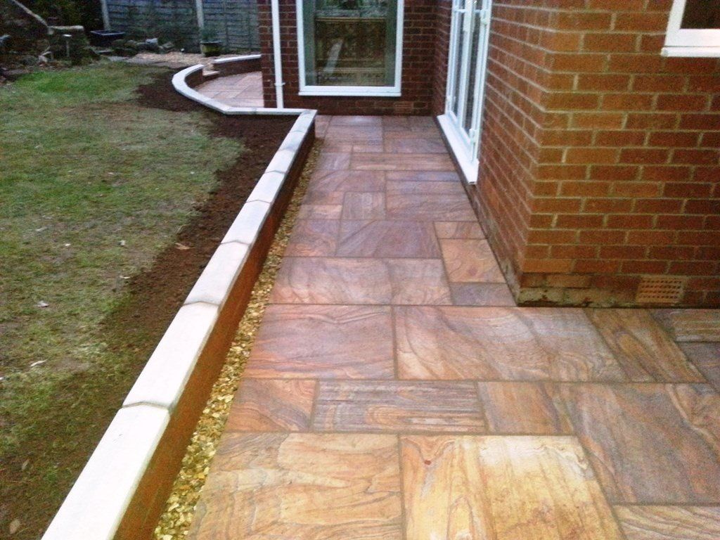 A brick building with a tiled walkway leading to it.
