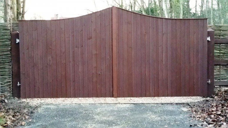 A wooden gate is sitting on the side of a road.
