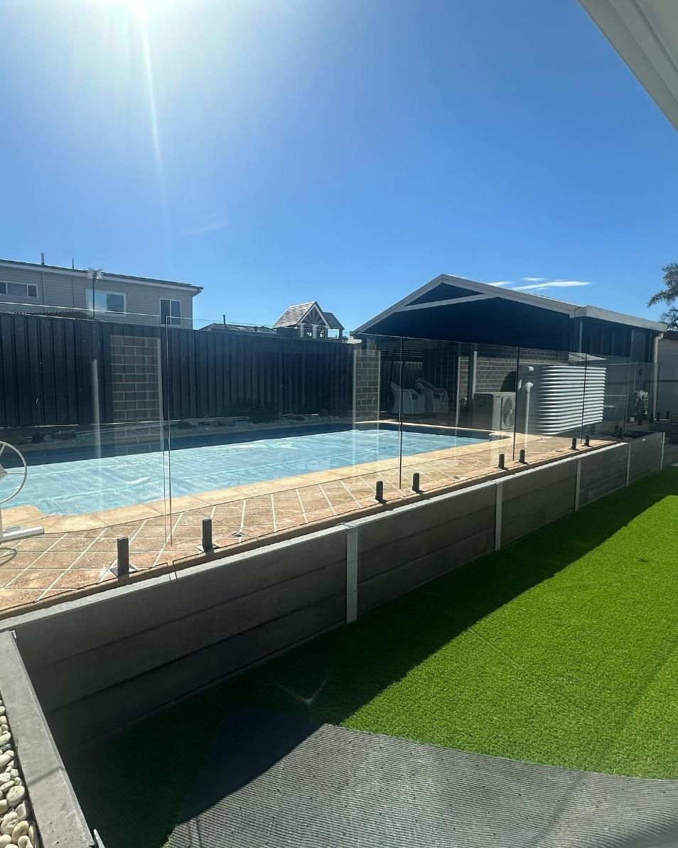 There Is a Large Swimming Pool in The Backyard of A House — Optimum Aluminium Fabrication in Barrack Heights, NSW