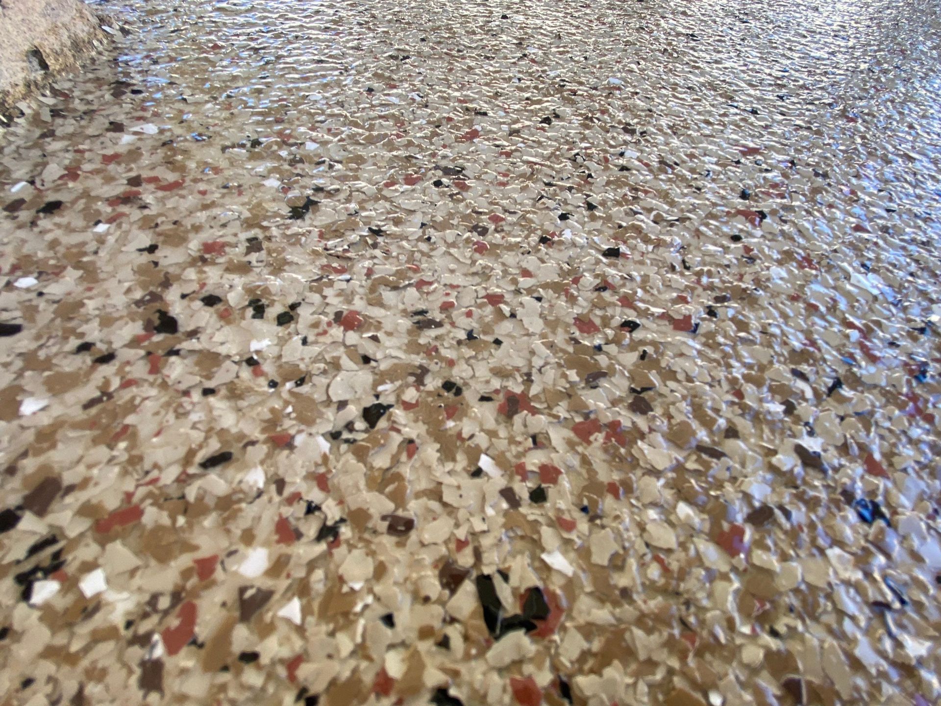 Speckled epoxy floor in various shades of brown, white, and black.
