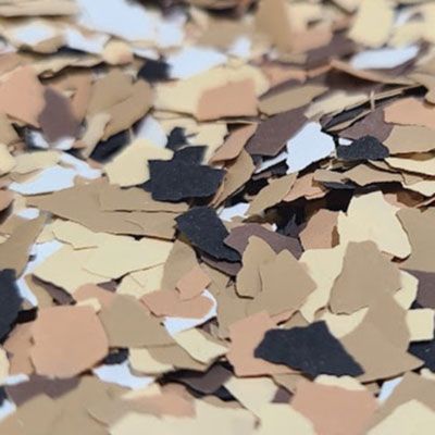 Brown, beige, black, and white decorative floor chips scattered on a surface.