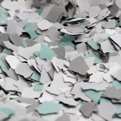 Close-up of gray, light gray, and teal paint flakes.