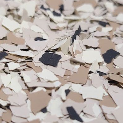 Close-up of speckled, beige and brown floor coating flakes.