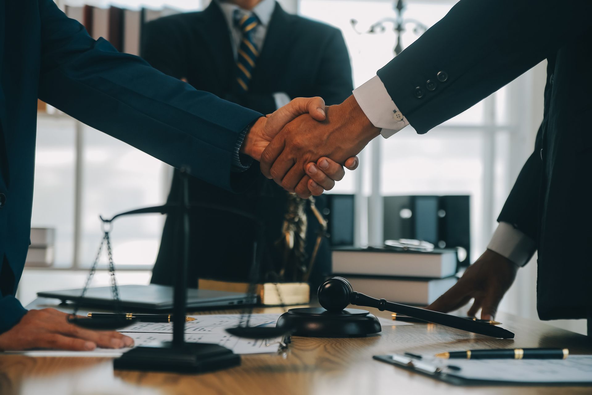 A group of business people shaking hands in front of a judge 's gavel.