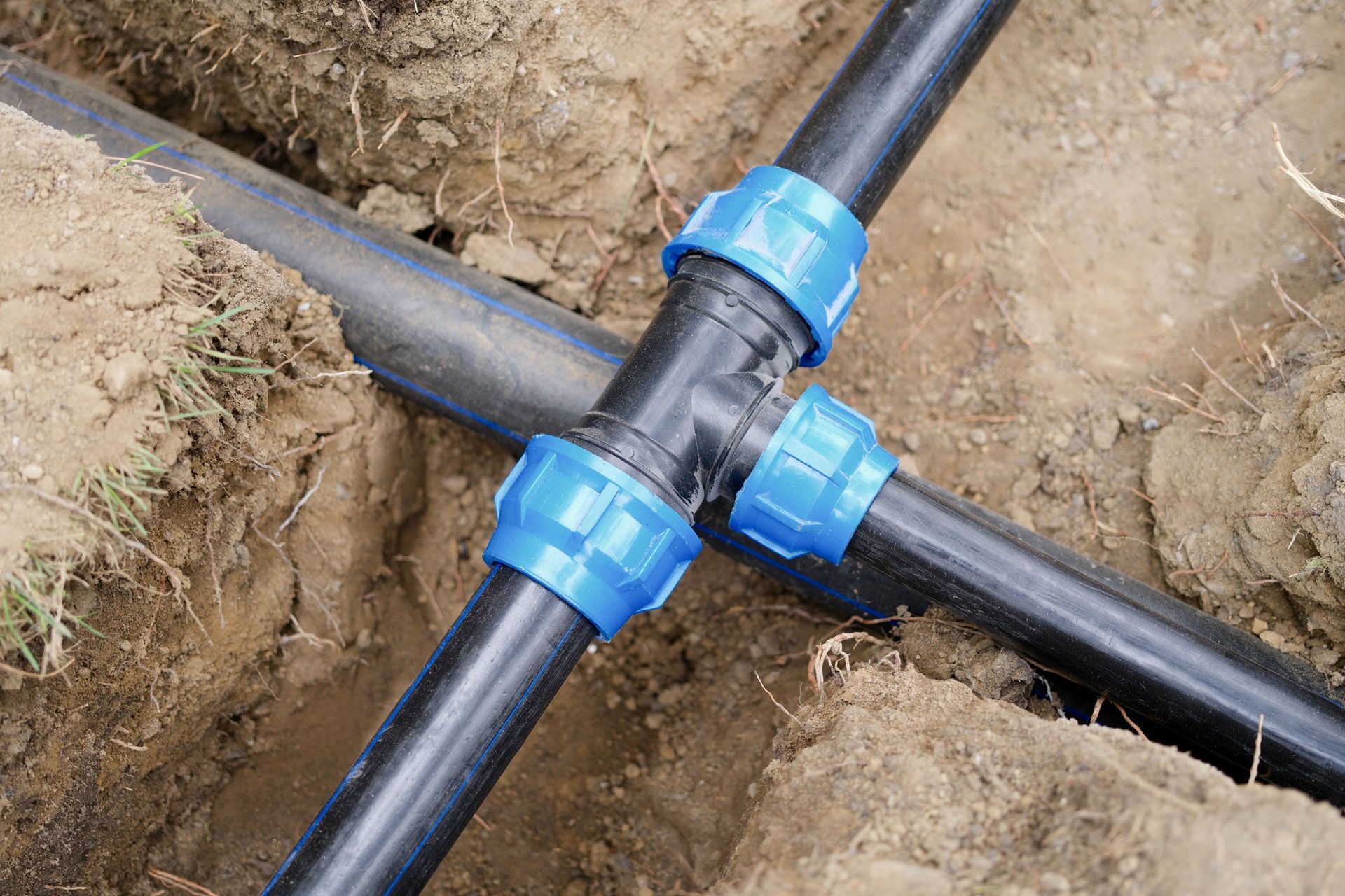 A close up of a hose connected to a pipe in the dirt.