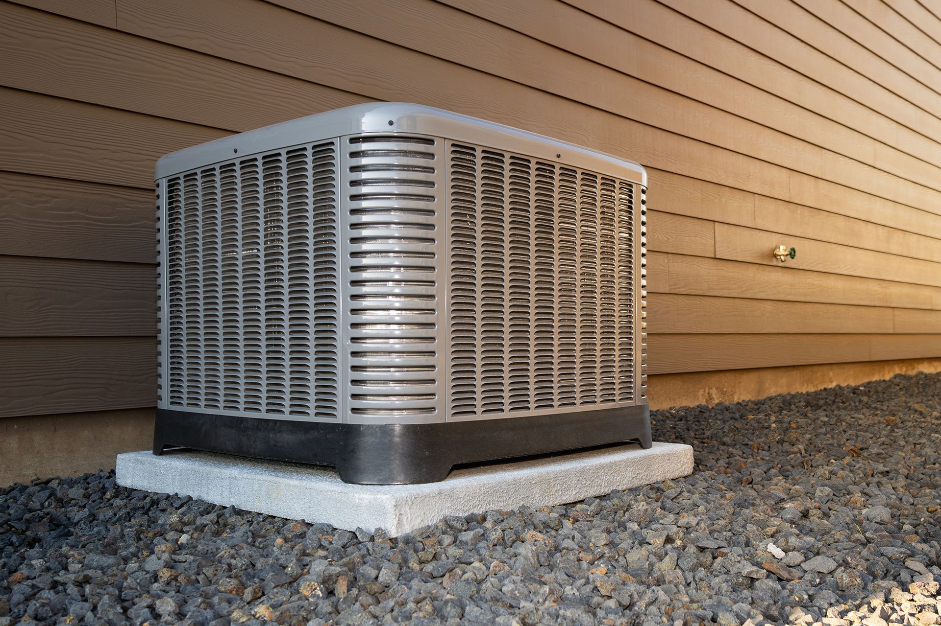 A man is working on an air conditioner and giving a thumbs up.