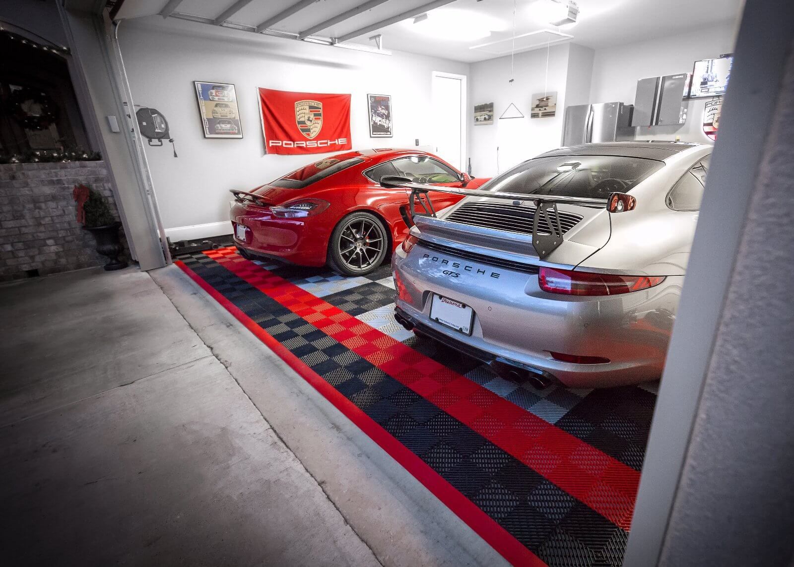 Two porsche cars are parked in a garage.