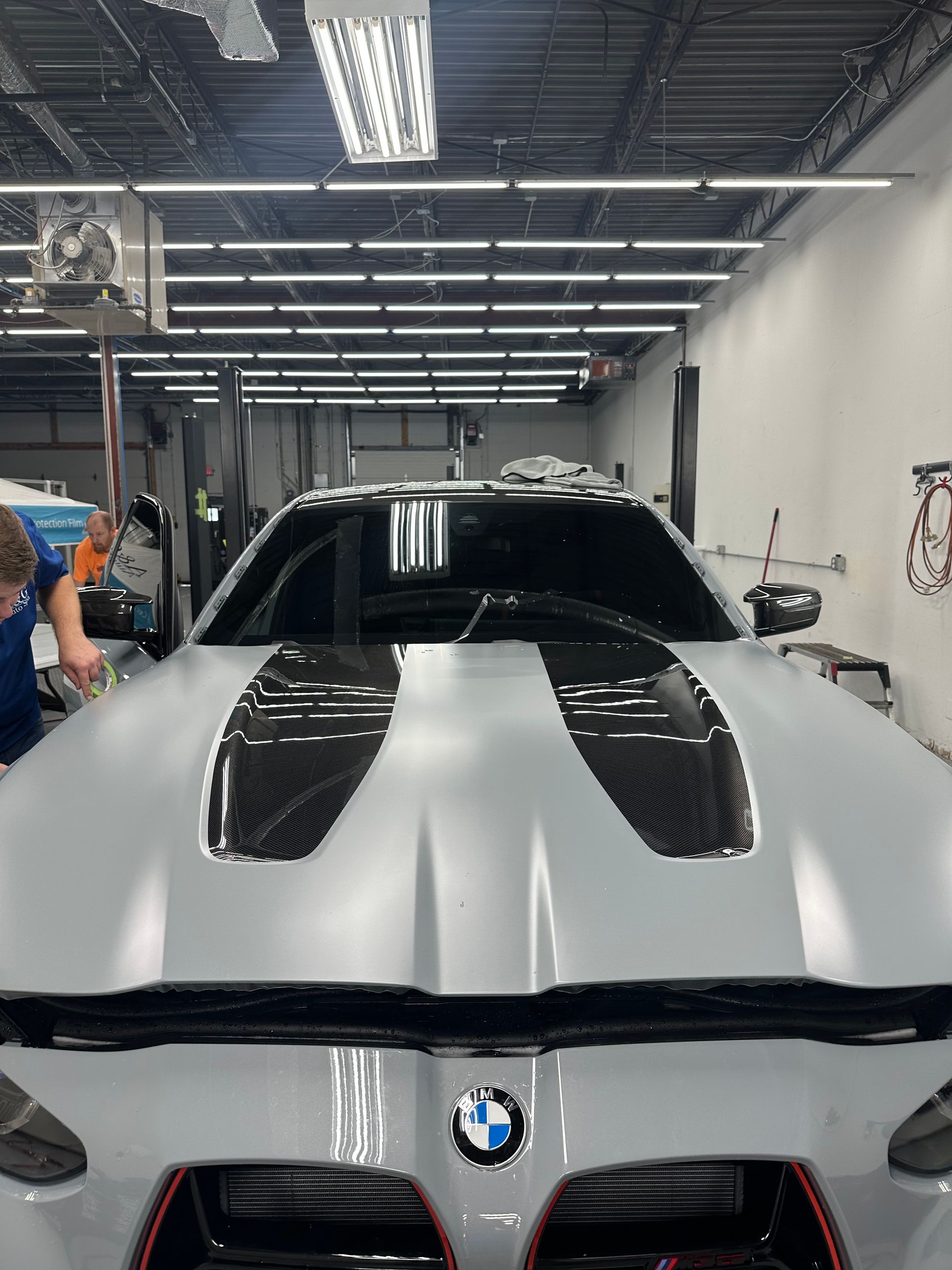 A man is working on a bmw in a garage.