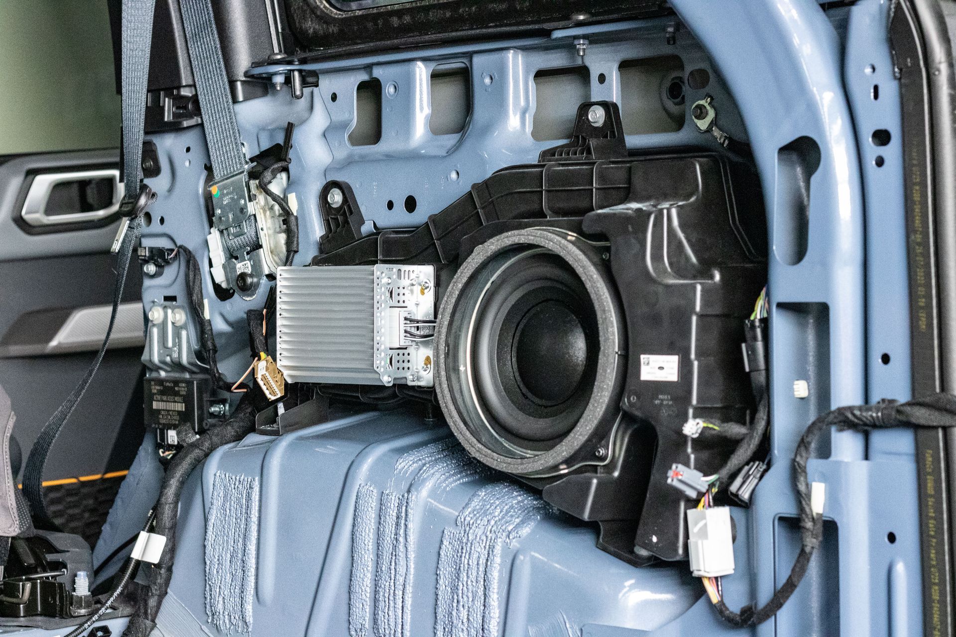 Car trunk setup with a laptop, tripod camera, and LED-lit equipment inside a vehicle.