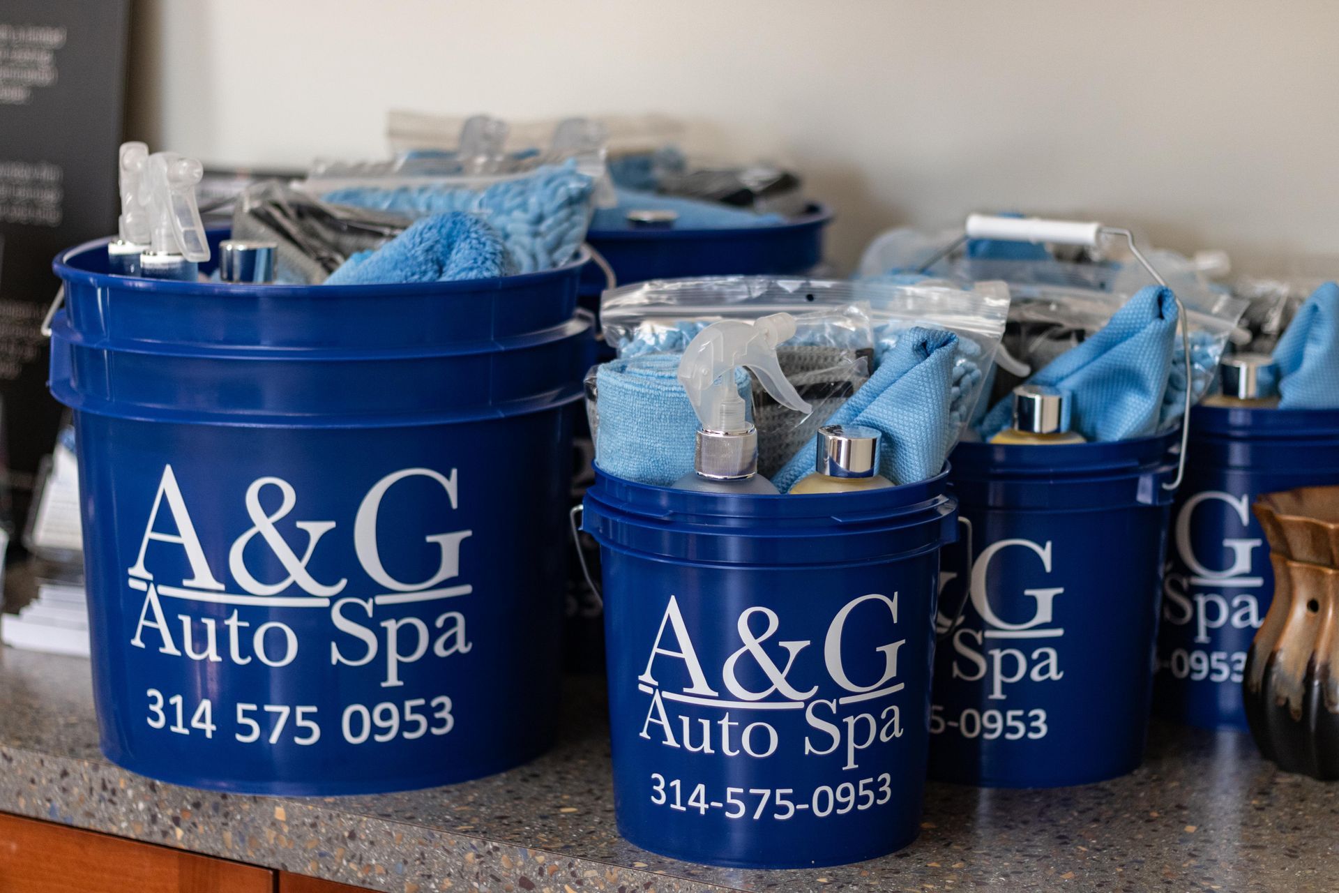 A row of blue buckets with a & g auto spa written on them
