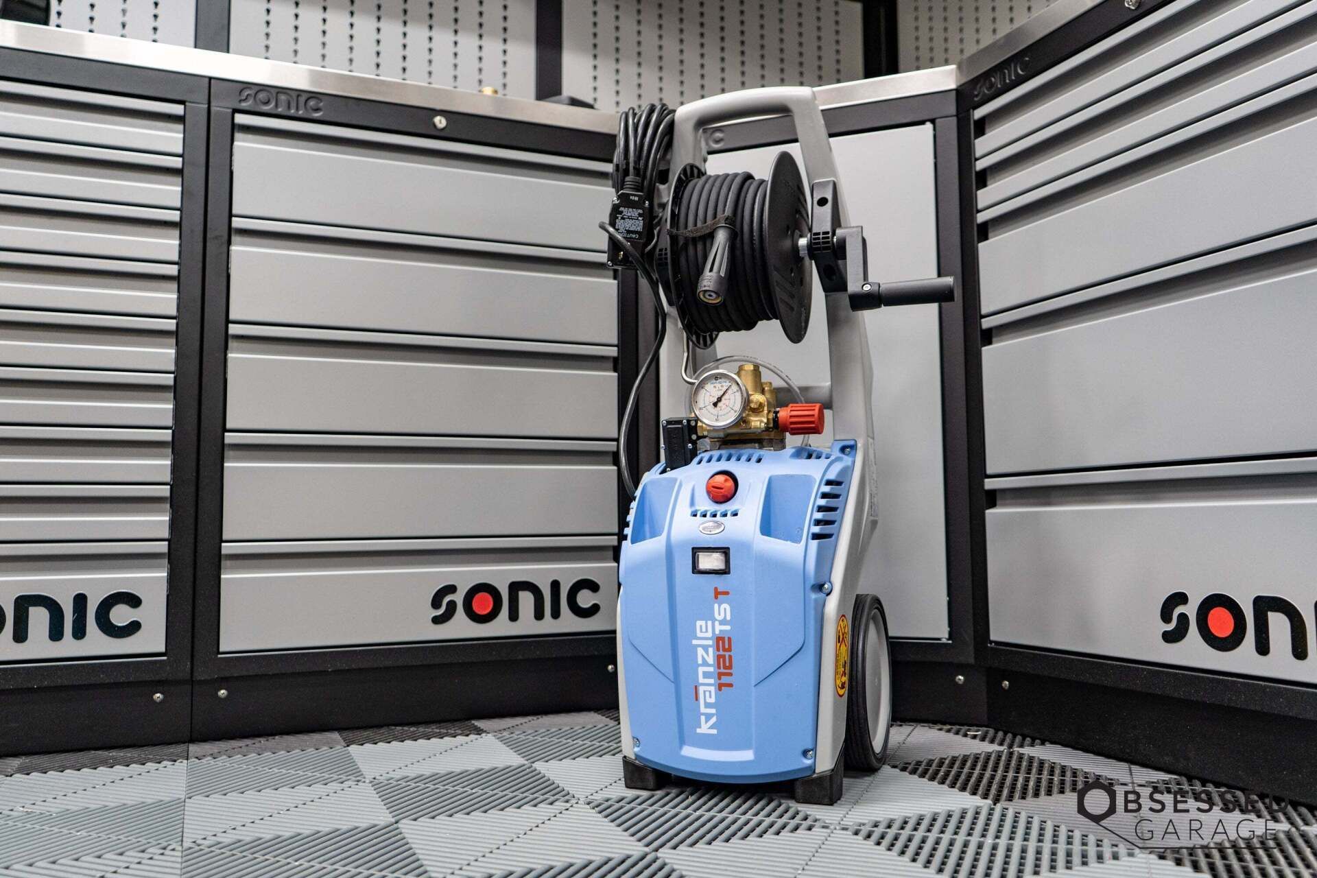 A sonic high pressure washer is sitting in a garage.
